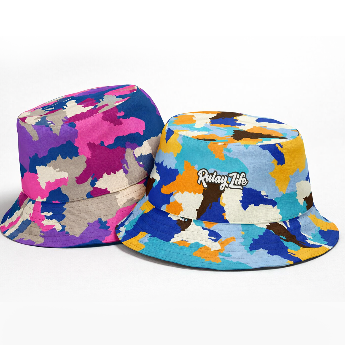 Two colorful bucket hats with camouflage patterns on a white background Dominican-Camo-Reversible-bucket-hat-_Retro-Remix-Fuchsia_rulayLife